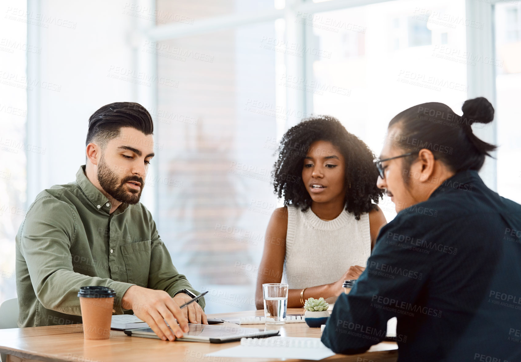 Buy stock photo Shot of a group of young businesspeople having a meeting in a modern office