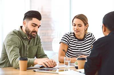 Buy stock photo Shot of a group of young businesspeople having a meeting in a modern office