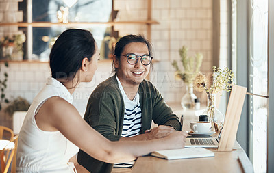 Buy stock photo Shot of young business partners sitting and talking with each other in a coffee shop during the day