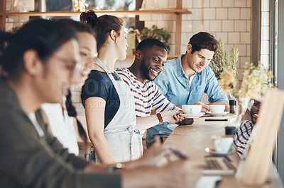 Buy stock photo Shot of a friendly young waitress serving coffee to young business partners in a coffee shop during the day