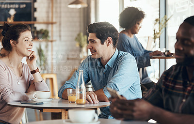 Buy stock photo Shot of an affectionate young couple sitting with each other in a coffee shop during the day