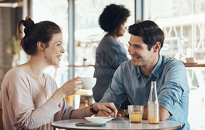 Buy stock photo Shot of an affectionate young couple sitting with each other in a coffee shop during the day
