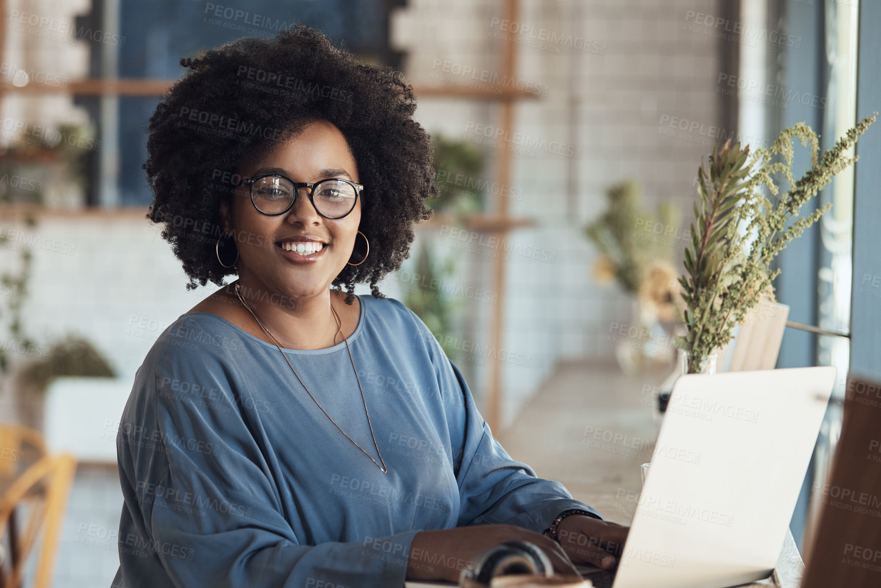 Buy stock photo Portrait of an attractive young businesswoman sitting and working on her laptop in a coffee shop during the day