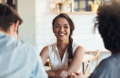 Buy stock photo Shot of an attractive young woman sitting and smiling with her friends in a coffee shop during the day