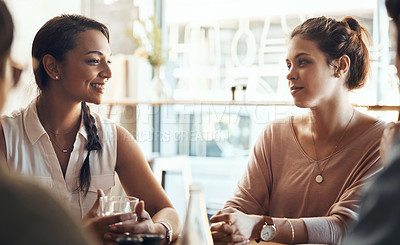 Buy stock photo Shot of attractive young women sitting together in a coffee shop during the day