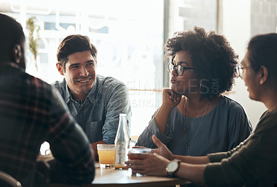 Buy stock photo Shot of a diverse young group sitting together in a coffee shop during the day