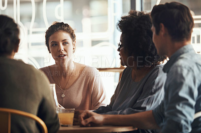 Buy stock photo Shot of a happy young diverse group sitting together in a coffee shop during the day