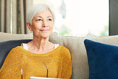Buy stock photo Shot of a senior woman using a digital tablet on the sofa at home