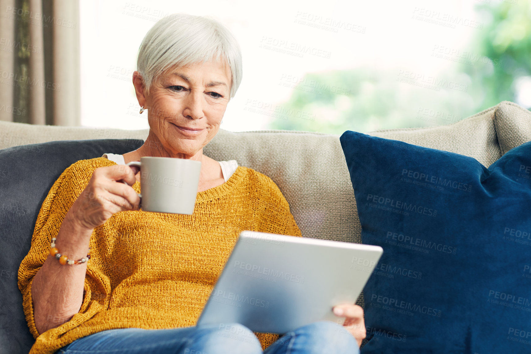 Buy stock photo Tablet, tea and old woman on couch to relax, reading news article or digital literature online. Tech, morning drink and happy person in home to check email, ebook story or newsletter in retirement