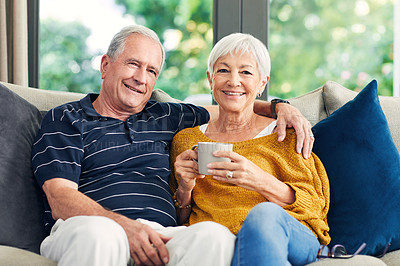 Buy stock photo Shot of a senior couple enjoying a coffee break on the sofa at home