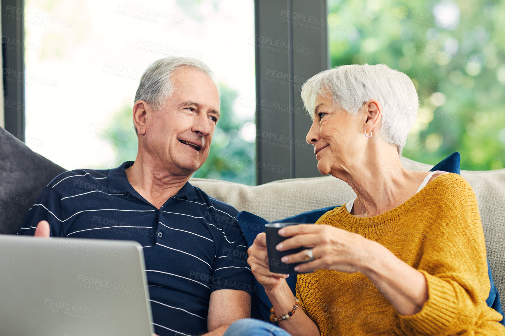 Buy stock photo Shot of a senior couple using a laptop on the sofa at home
