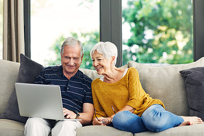 Buy stock photo Shot of a senior couple using a laptop on the sofa at home