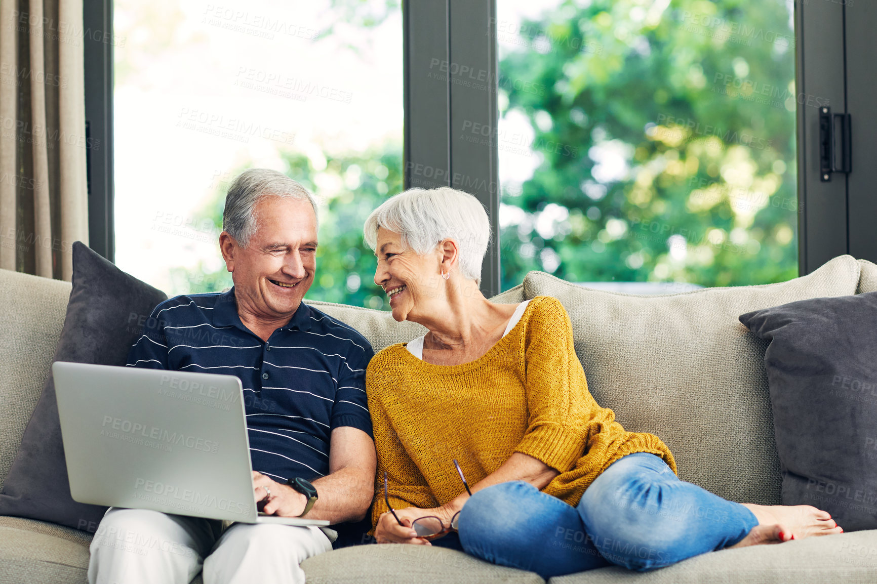 Buy stock photo Laptop, smile and elderly couple on sofa for video, streaming show or film together in living room. Love, tech and old man with woman in retirement for bonding, movie and subscription in home