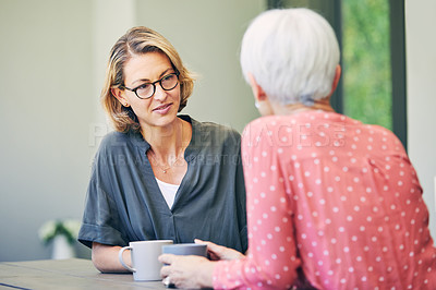 Buy stock photo Shot of a mature woman and her elderly mother having coffee and a chat at home