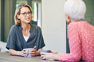 Buy stock photo Shot of a mature woman and her elderly mother having coffee and a chat at home