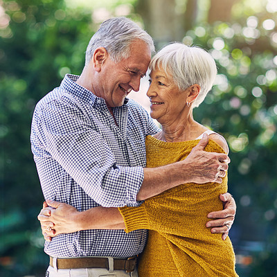 Buy stock photo Shot of a happy senior couple embracing outdoors