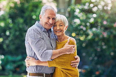 Buy stock photo Shot of a happy senior couple embracing outdoors