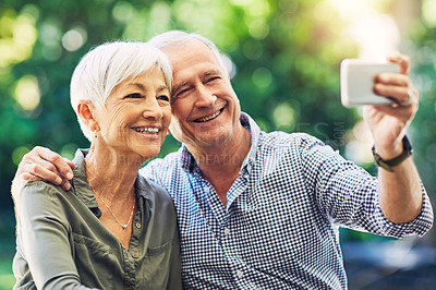 Buy stock photo Shot of a senior couple taking selfies together in their backyard