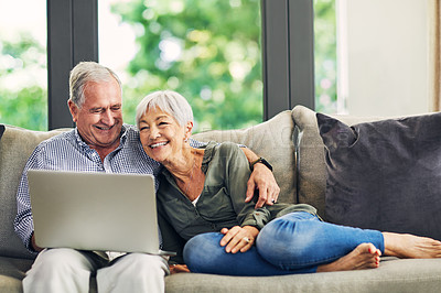 Buy stock photo Shot of a senior couple using a laptop on the sofa at home