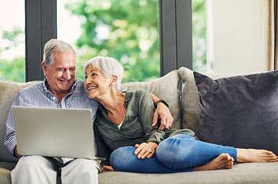 Buy stock photo Shot of a senior couple using a laptop on the sofa at home
