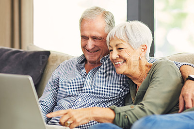 Buy stock photo Shot of a senior couple using a laptop on the sofa at home