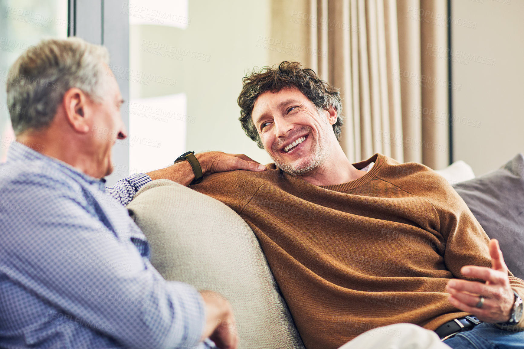 Buy stock photo Shot of a mature man and his elderly father sitting on the sofa at home and chatting