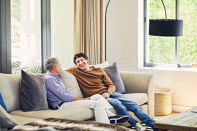 Buy stock photo Shot of a mature man and his elderly father sitting on the sofa at home and chatting