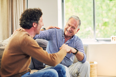Buy stock photo Shot of a mature man and his elderly father sitting on the sofa at home and chatting