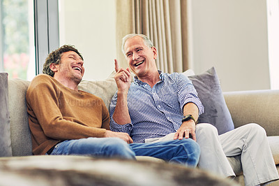 Buy stock photo Shot of a mature man and his elderly father sitting on the sofa at home and chatting