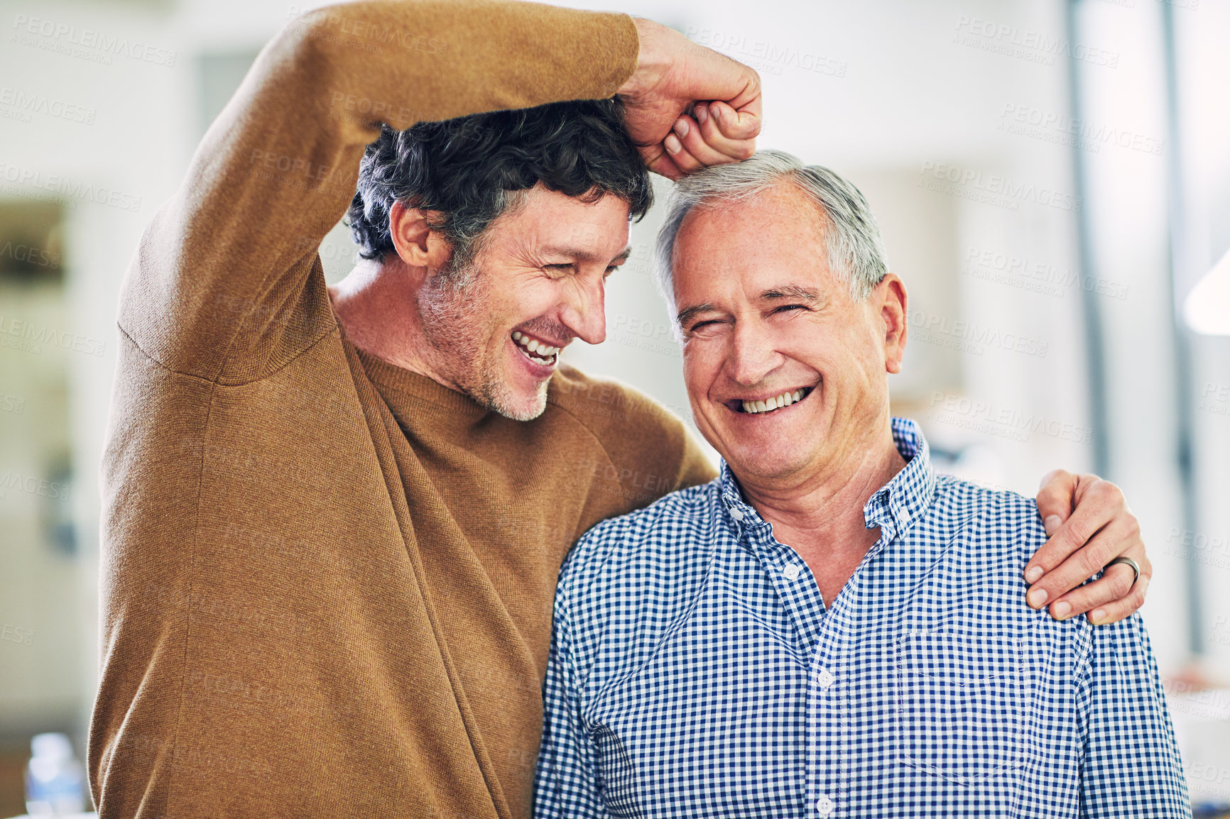 Buy stock photo Shot of a mature man and his elderly father having having a playful moment at home
