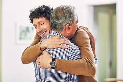 Buy stock photo Shot of a mature man and his elderly father embracing each other at home