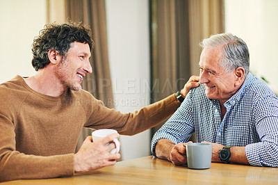 Buy stock photo Shot of a mature man and his elderly father having coffee and a chat at home