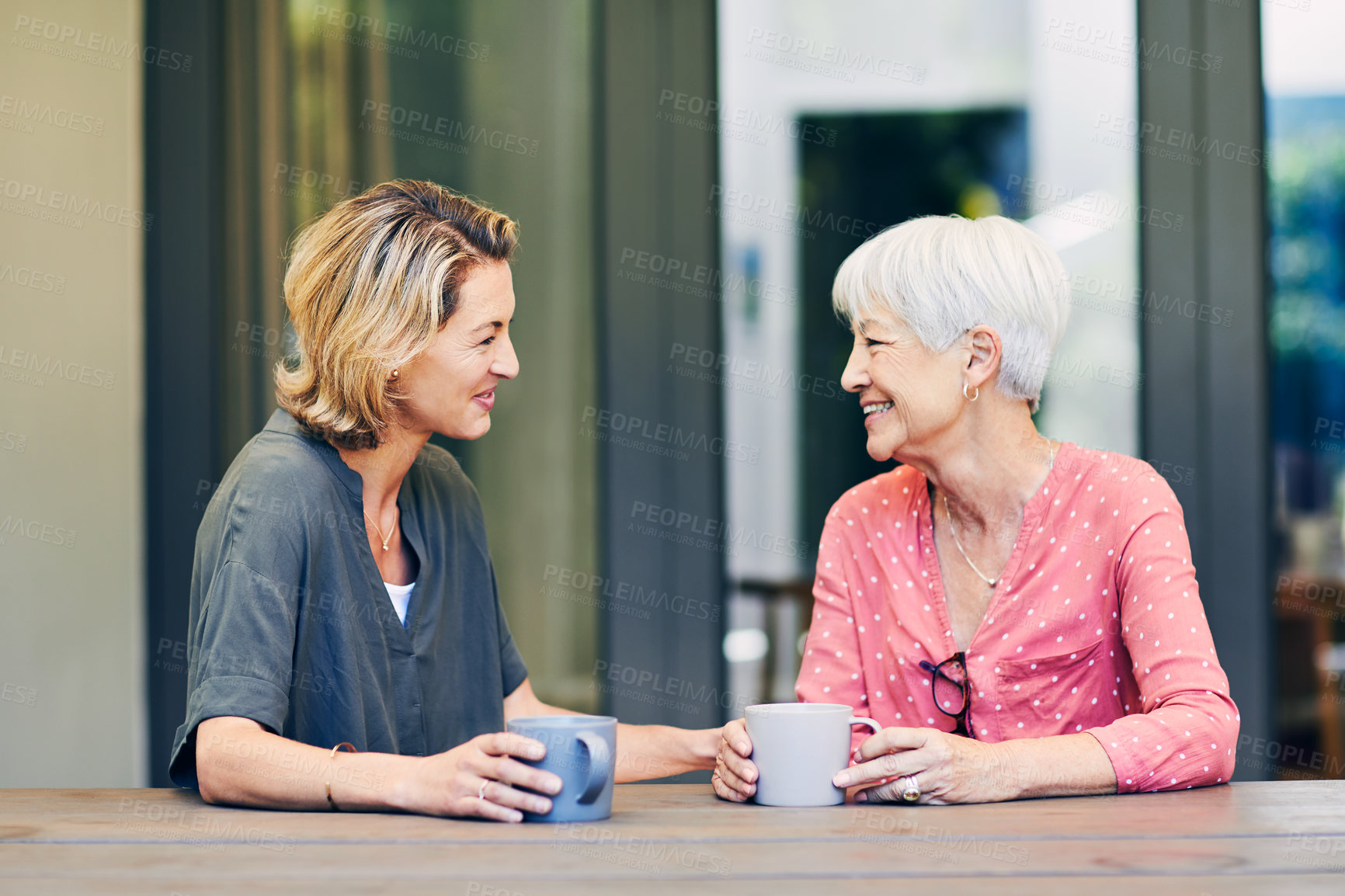 Buy stock photo Shot of a mature woman and her elderly mother having coffee and a chat at home