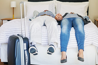 Buy stock photo Shot of a senior couple relaxing on a bed in their hotel room