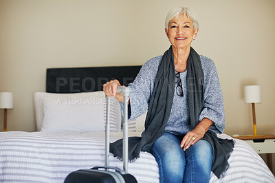 Buy stock photo Shot of a happy senior woman sitting on a bed in her hotel room