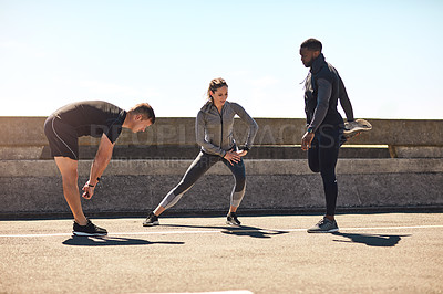Buy stock photo Shot of a group of sporty young people out exercising together