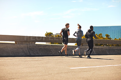 Buy stock photo Shot of a group of sporty young people out exercising together