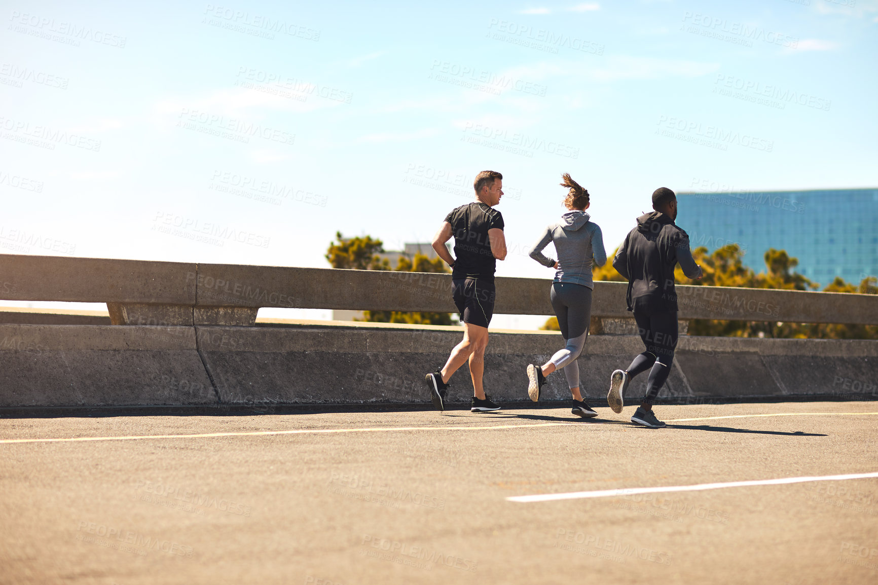 Buy stock photo Shot of a group of sporty young people out exercising together