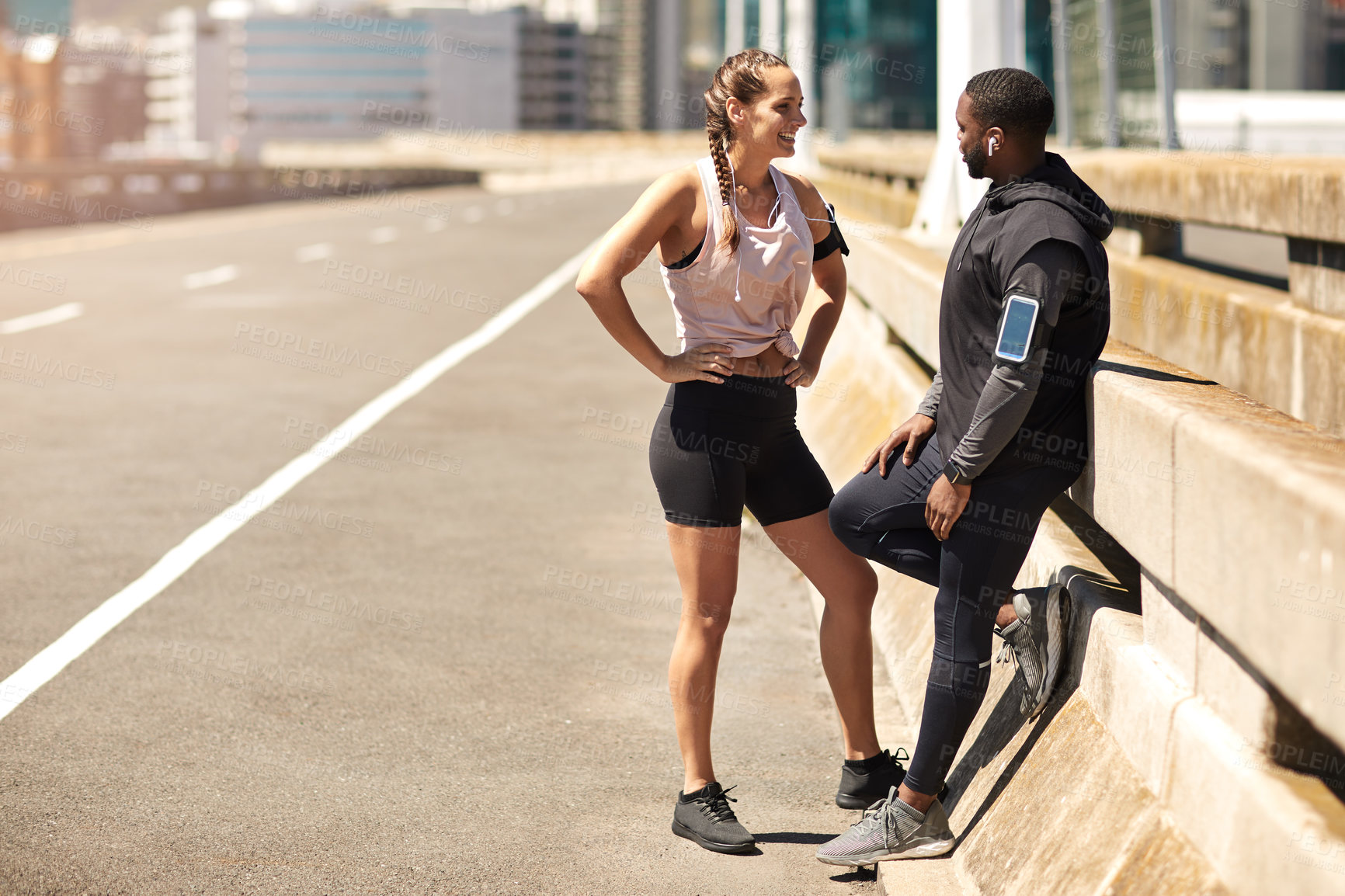 Buy stock photo Shot of two sporty young people standing together while out for a run
