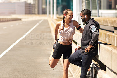 Buy stock photo Shot of two sporty young people standing together while out for a run