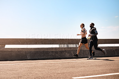 Buy stock photo Shot of two sporty young people out for a run