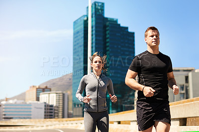 Buy stock photo Shot of two sporty young people out for a run