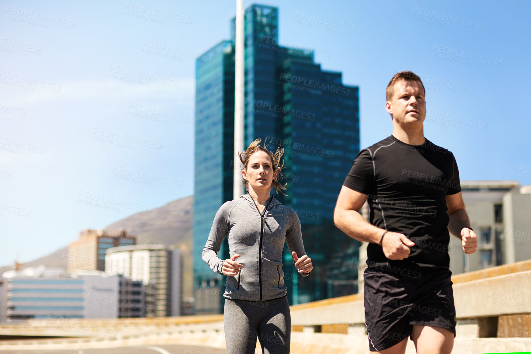 Buy stock photo Shot of two sporty young people out for a run
