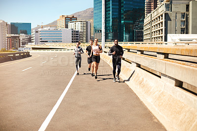 Buy stock photo Shot of a group of sporty young people out exercising together