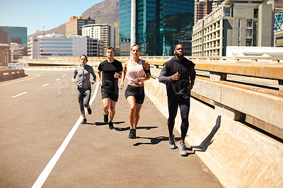 Buy stock photo Shot of a group of sporty young people out exercising together