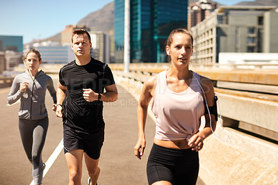 Buy stock photo Shot of a group of sporty young people out exercising together