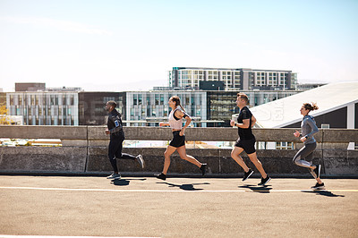 Buy stock photo Shot of a group of sporty young people out exercising together
