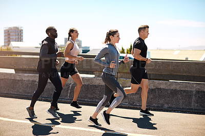 Buy stock photo Shot of a group of sporty young people out exercising together