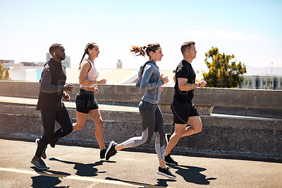Buy stock photo Shot of a group of sporty young people out exercising together