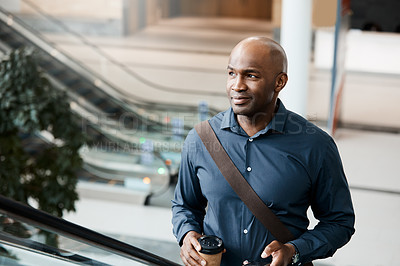 Buy stock photo Cropped shot of a handsome businessman texting while standing on an escalator in his office